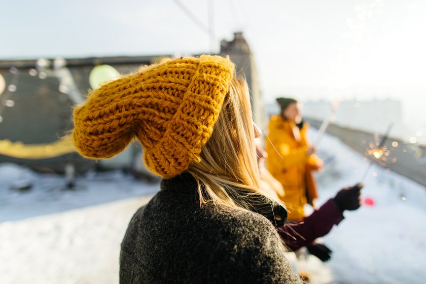 Neujahrsrituale: Frau feiert im Schnee