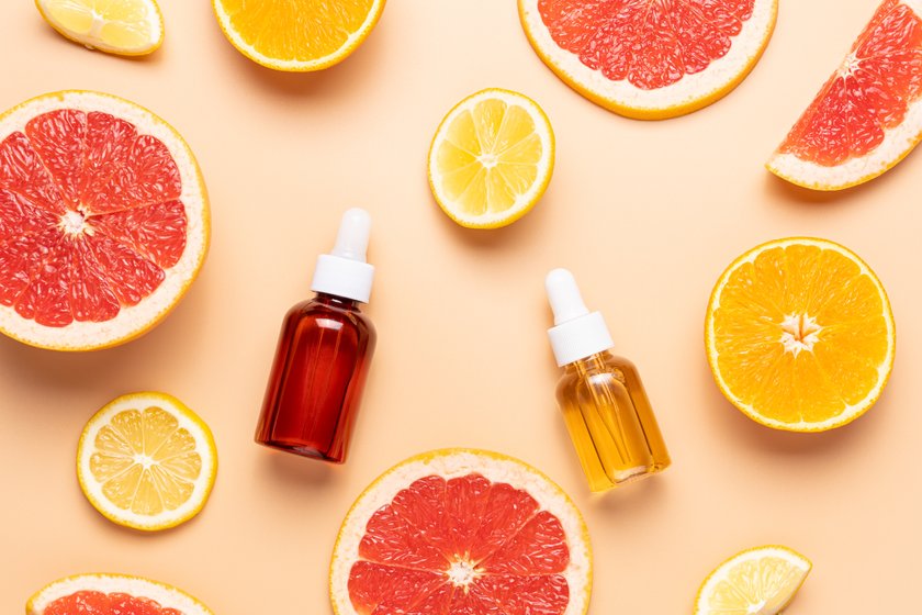 Slice of grapefruit, orange, lemon and set of cosmetic bottles on beige background, top view Slice of grapefruit, orange, lemon and set of cosmetic bottles on beige background, top view