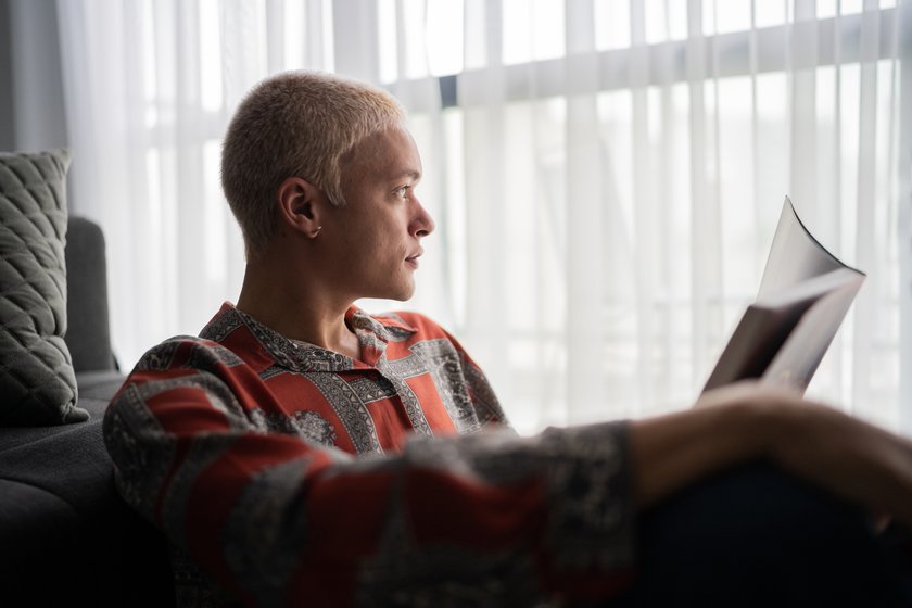 Junger Mann liest ein Buch und ist dabei nachdenklich Junger Mann liest ein Buch und ist dabei nachdenklich