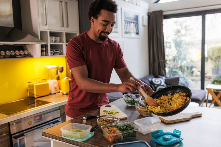 Mann kocht mehrere Gerichte vegan