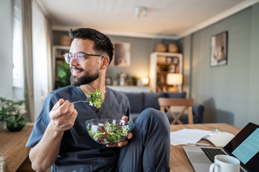 Mann isst Salat in MIttagspause Mann isst Salat in MIttagspause