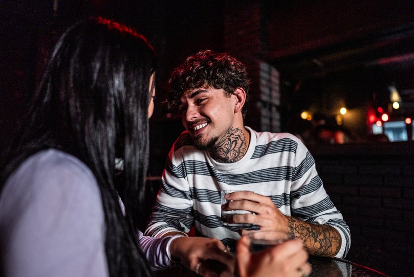 Junge Menschen flirten im Pub