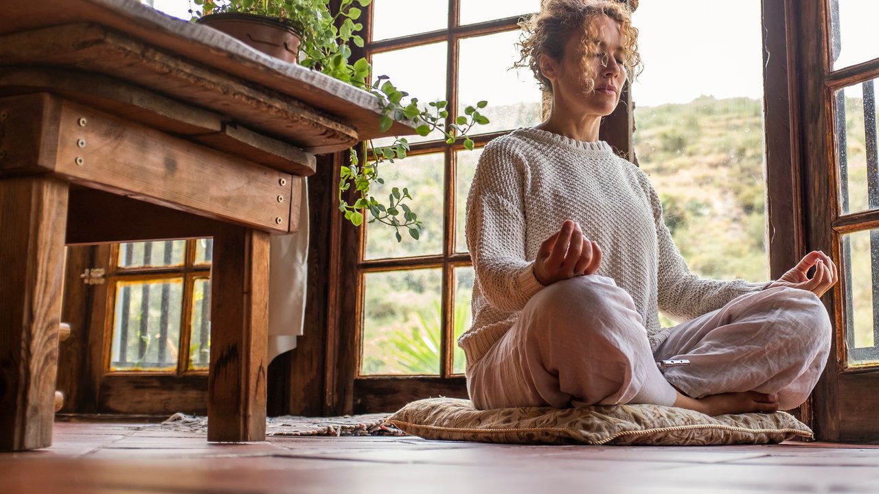 Healthy lifestyle concept with adult woman doing yoga lotys position at home. Asana health positive mental wellbeing. Meditation zen like exercise sitting ont he floor at home. Morning activity alone