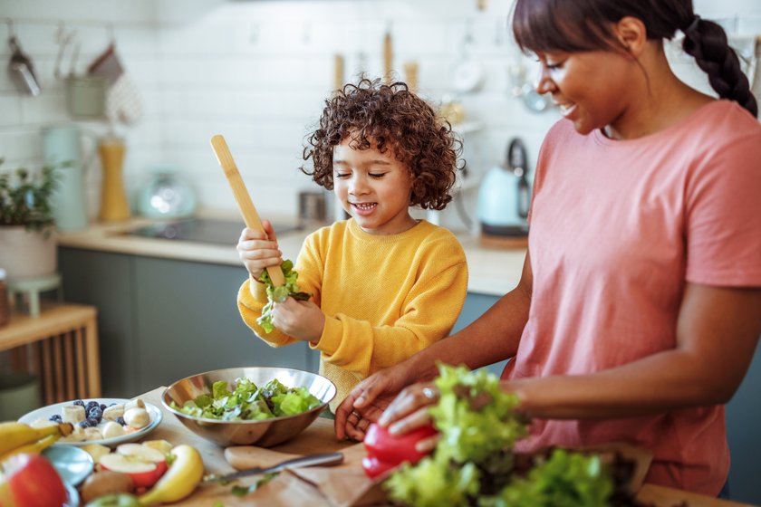 Frau und Kind kochen mit Gemüse